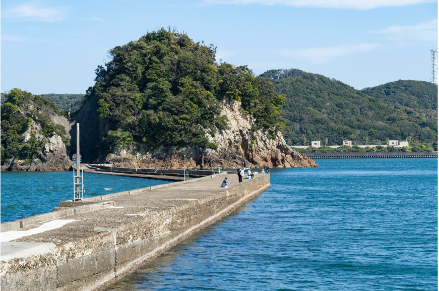 海に伸びる堤防と釣り場の風景